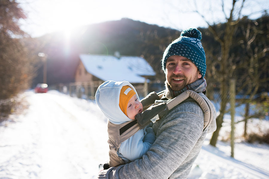 Personal Insurance - Father With a Baby in a Carrier on a Snowy Day